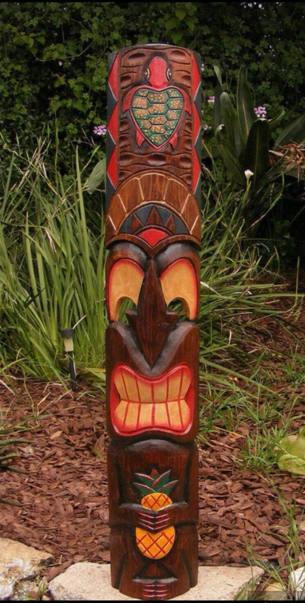 wooden tiki statue with pineapple motif in a garden