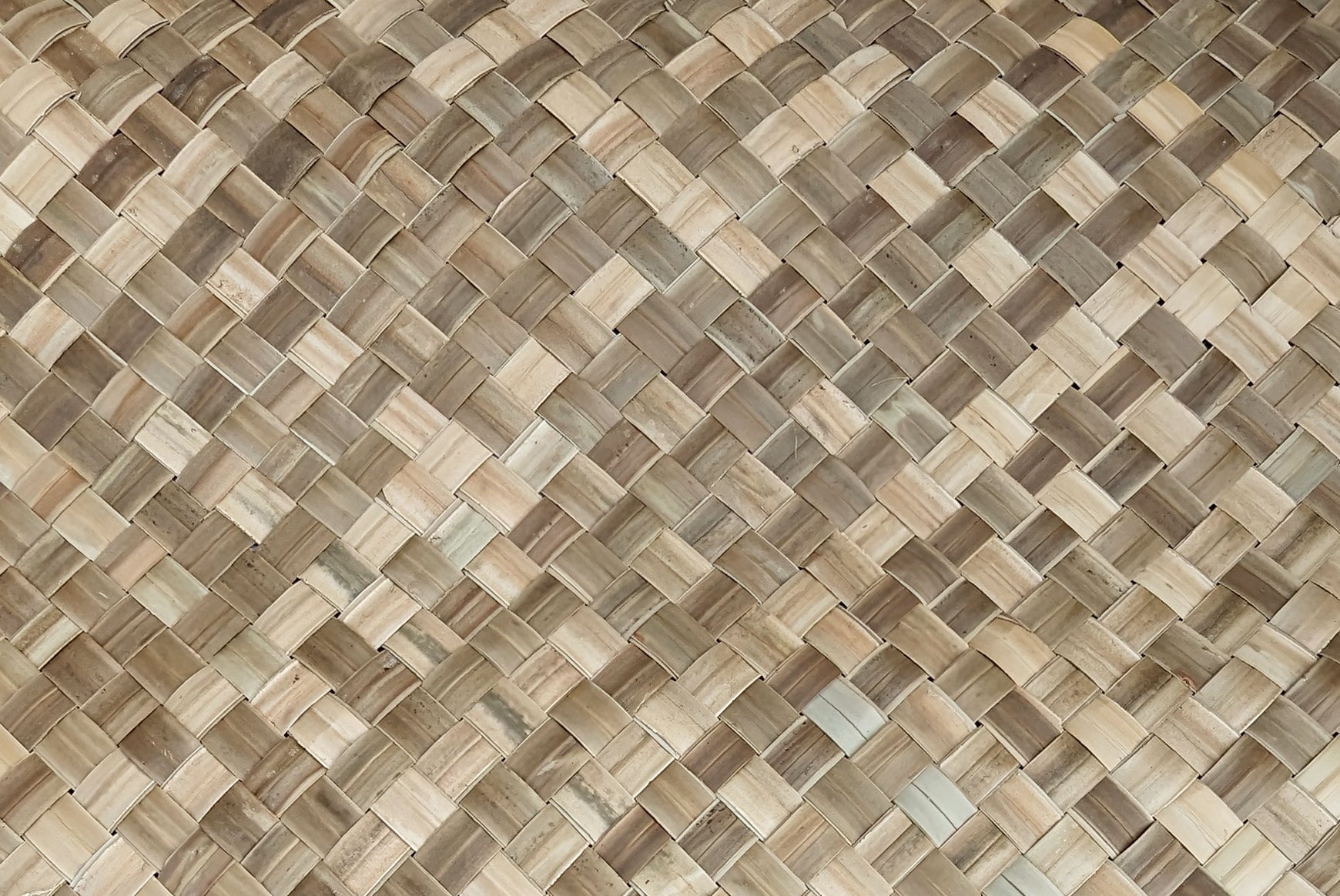 close-up of a woven palm-leaf mat in beige and brown tones