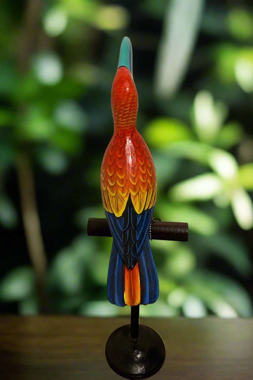 Colorful carved wooden parrot sculpture perched on a stand.