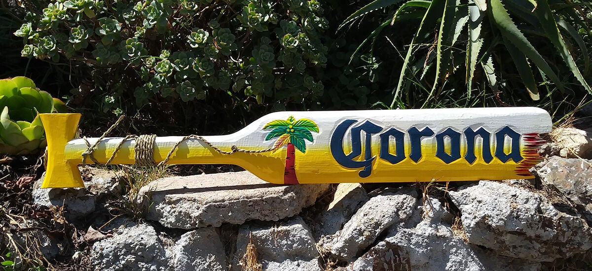 Decorative yellow Corona beer bottle painted with a palm tree garden ornament