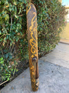 Decorative carved wooden staff with gold swirls and dotted pattern