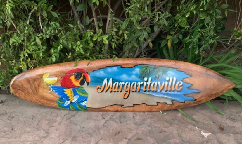 Wooden Margaritaville surfboard sign with colorful parrot illustration