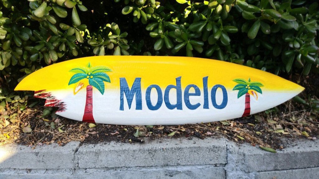 Modelo surfboard with yellow gradient and palm tree graphics