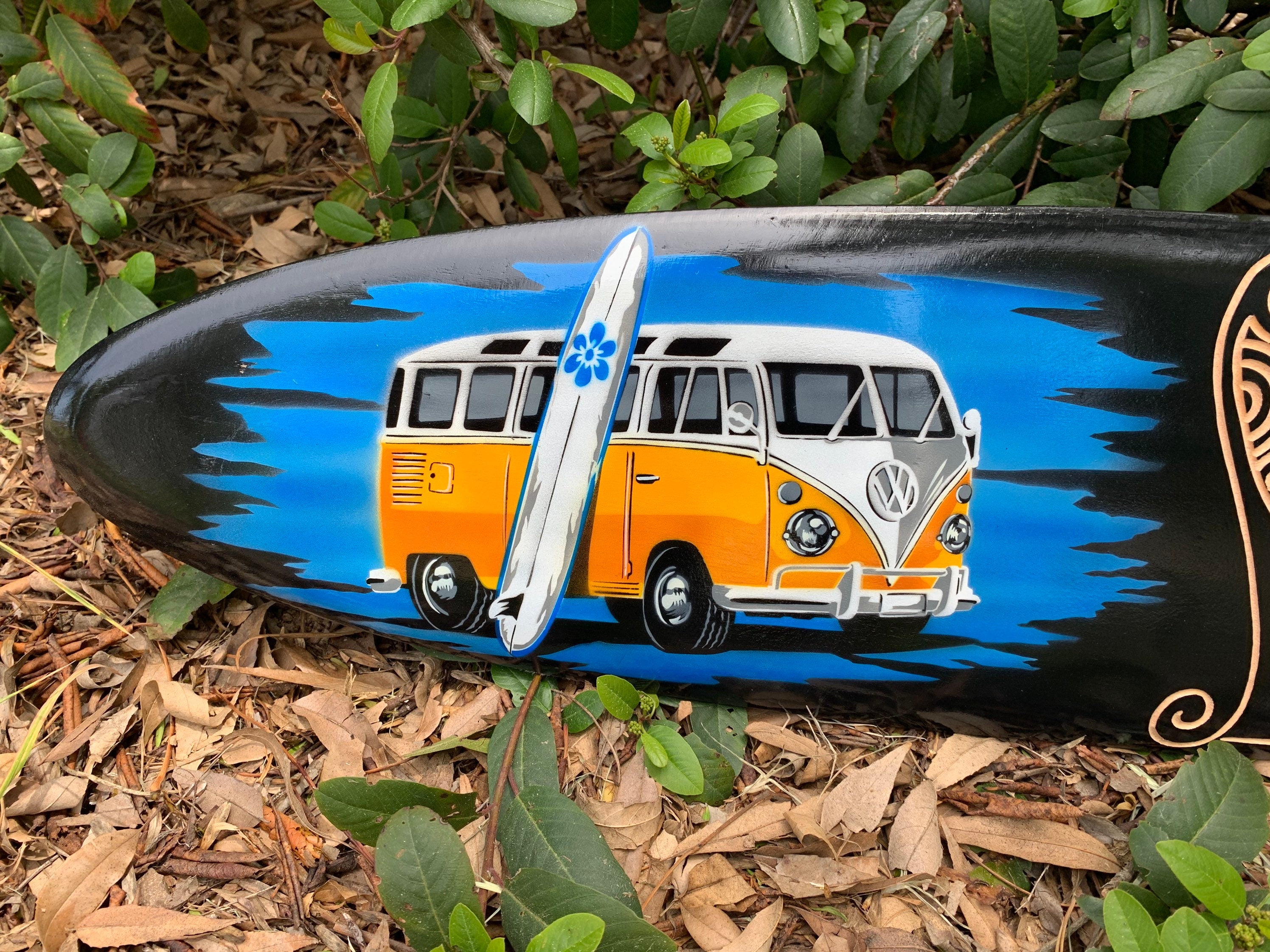 Painted retro orange and white VW bus on a surfboard with blue background