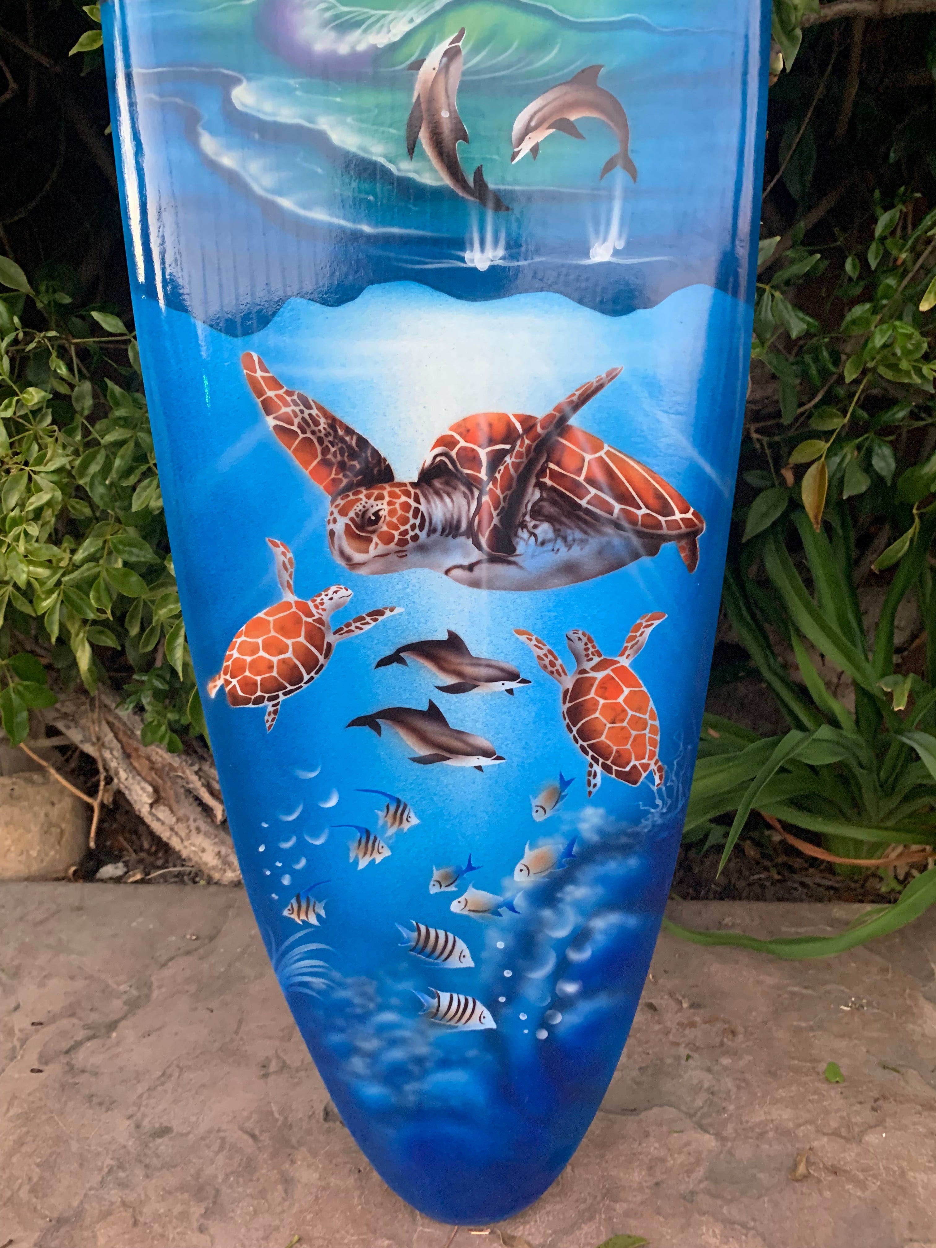 Blue vase with sea turtles and dolphins in an underwater scene.
