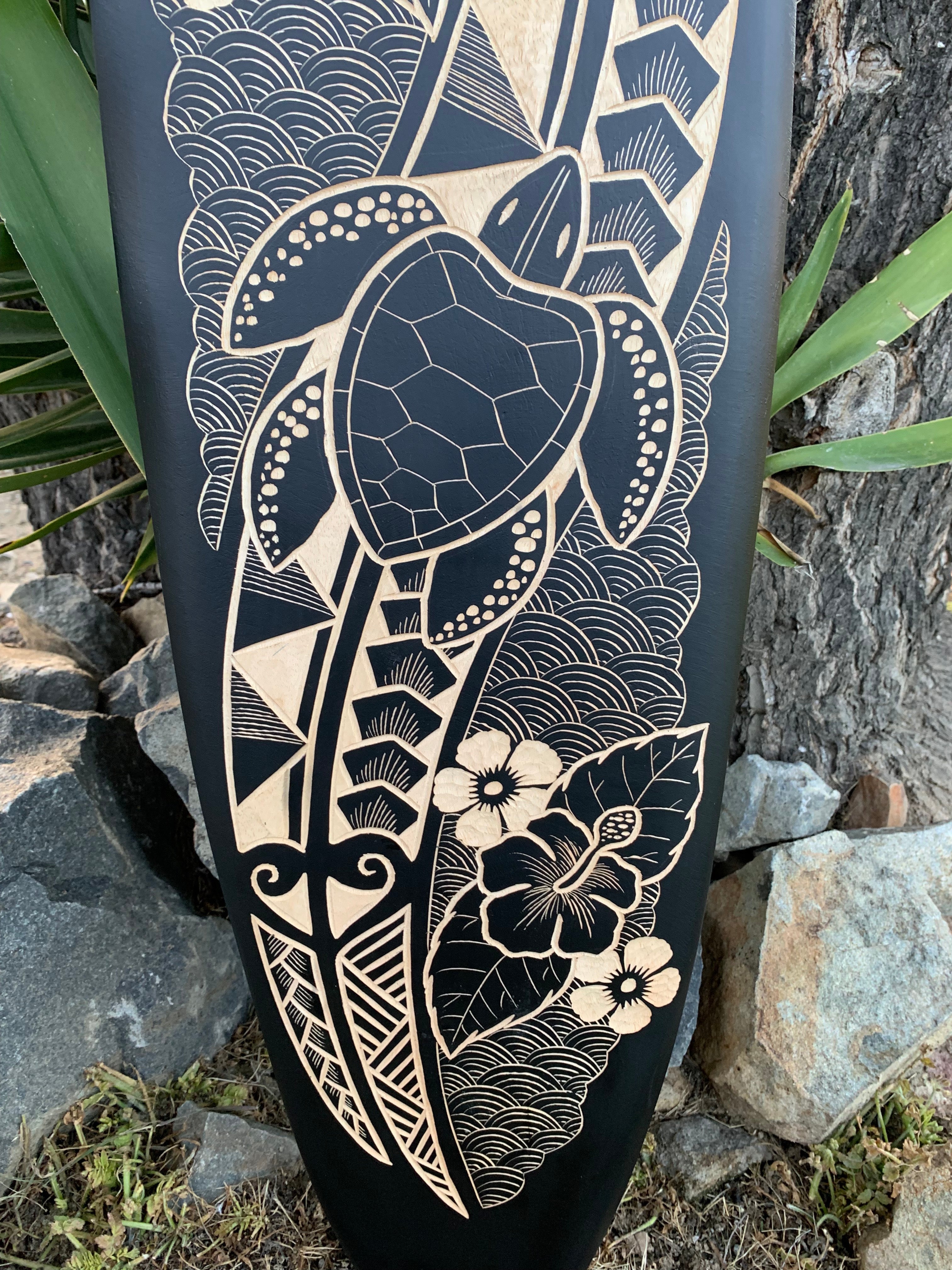Carved turtle with floral and wave patterns on a dark panel