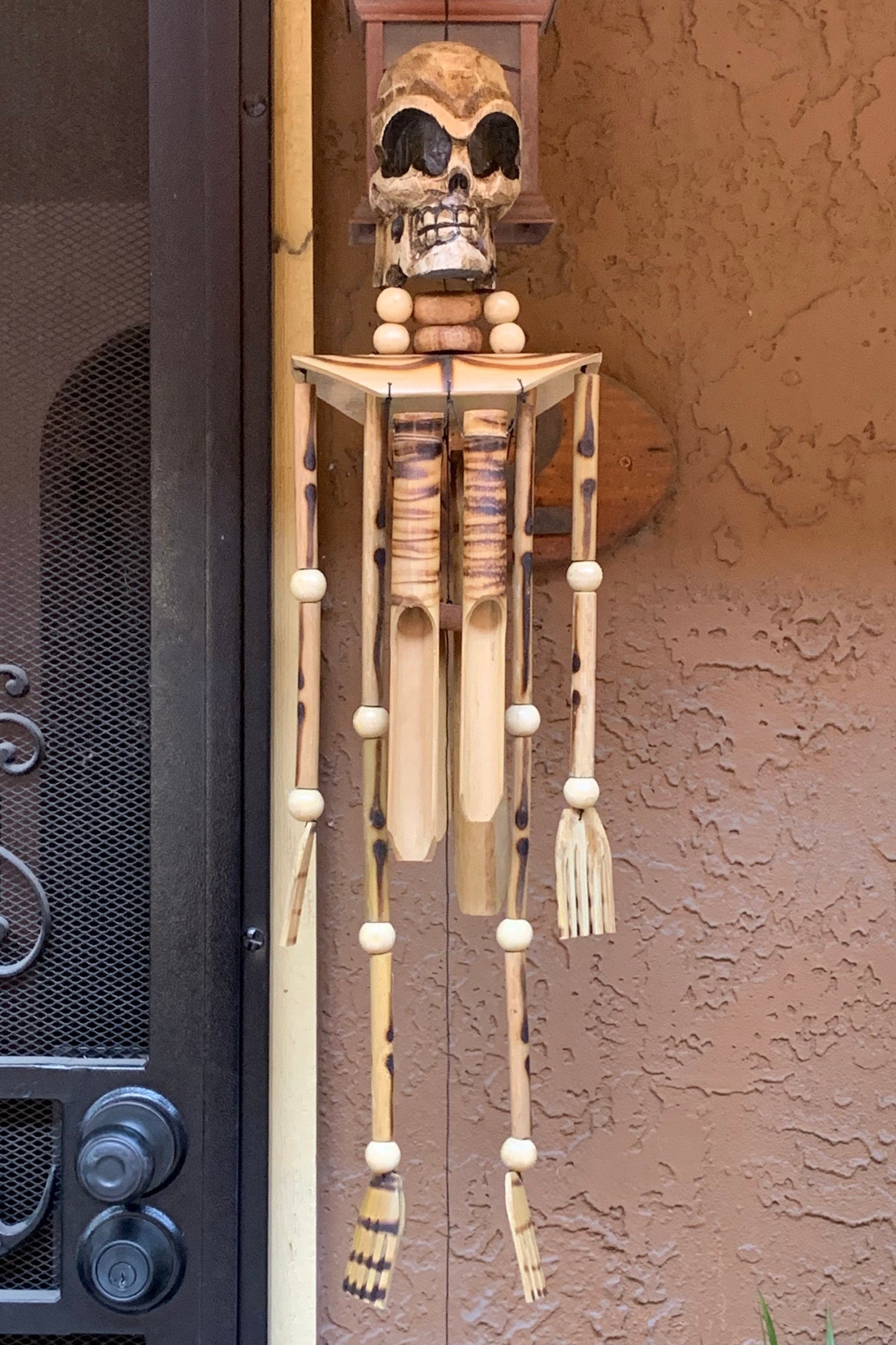 wooden skeleton wind chime with skull head